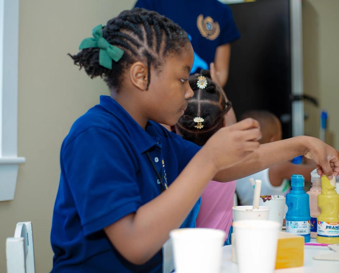 A child choosing paints in the classroom