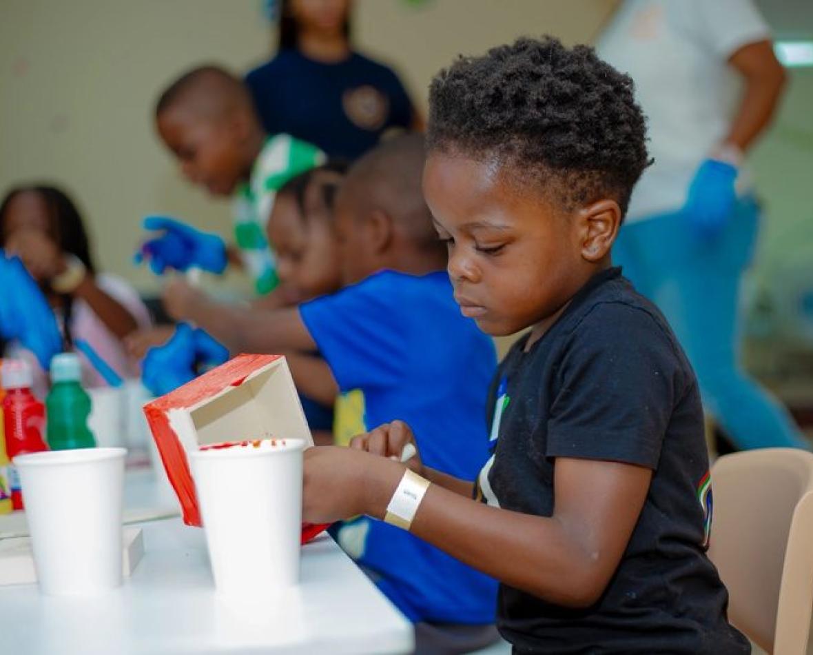 A boy concentrating on an art activity at the table