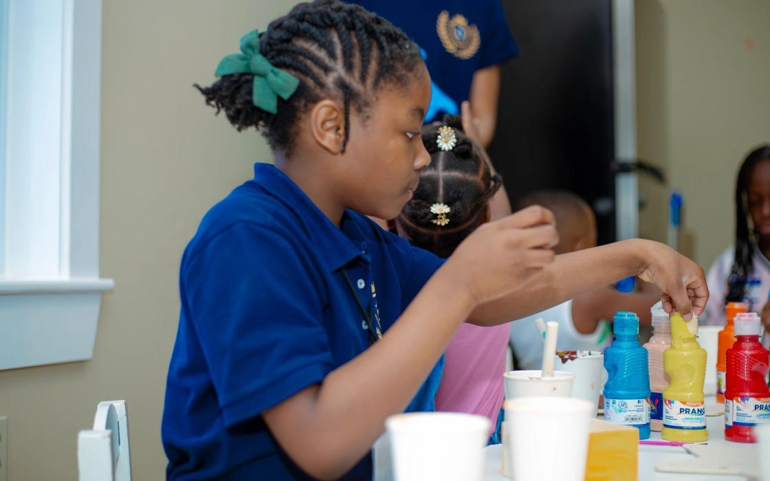 A child choosing paints in the classroom