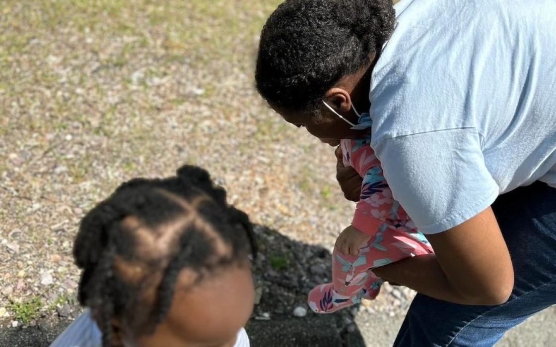 A teacher and child exploring the garden outdoors