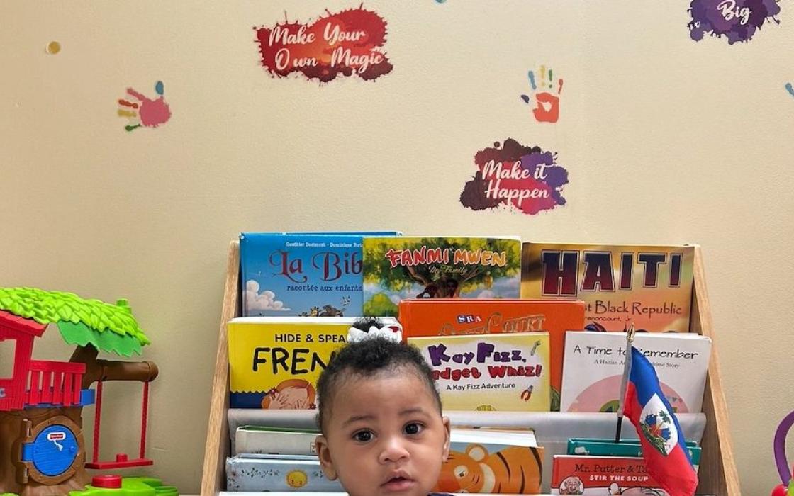 A child choosing a book from the reading corner