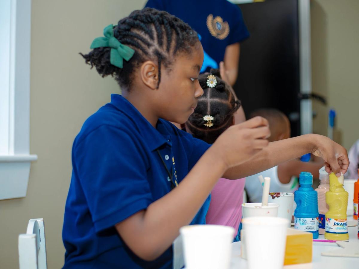 A child choosing paints in the classroom