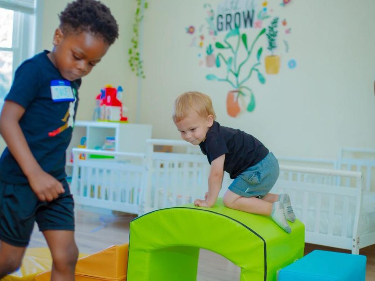 Toddlers playing on soft climbing equipment in the classroom